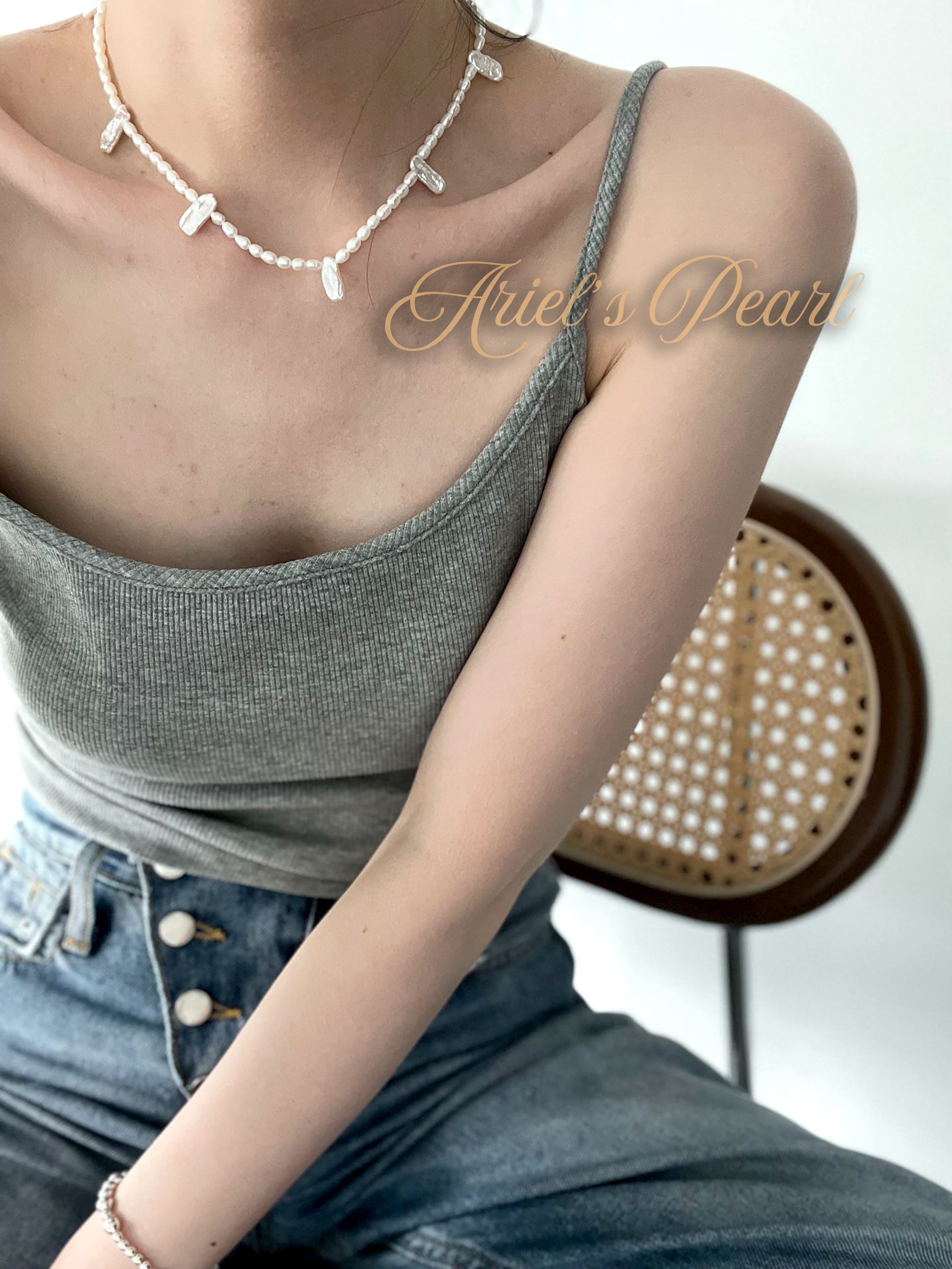Person wearing a pearl necklace with a blurred background